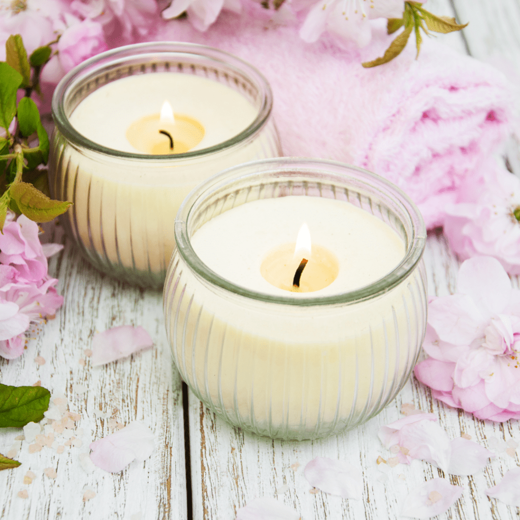 Pair of scented candles with flowers around them